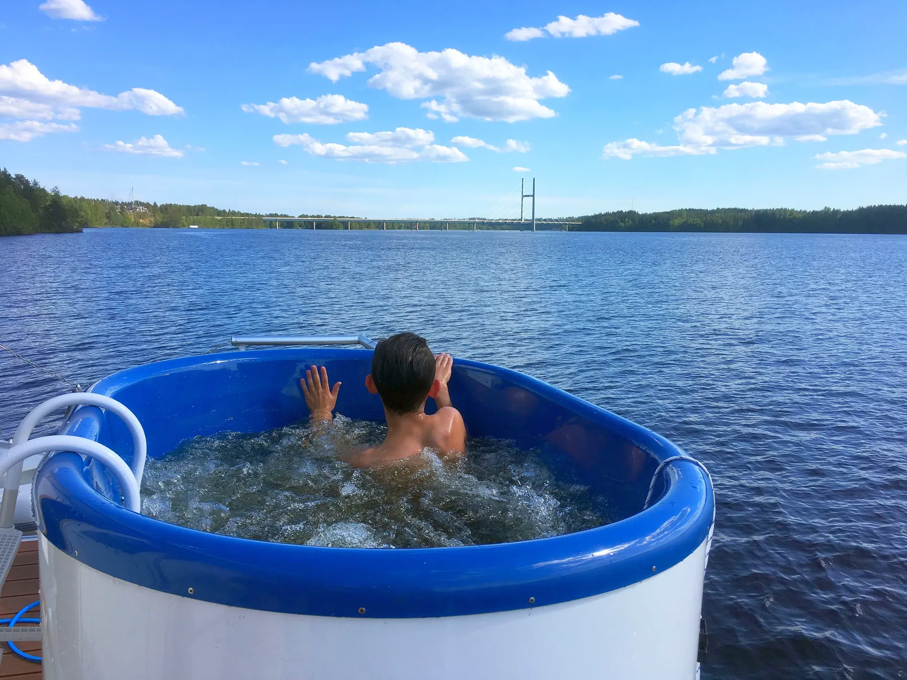Gast entspannt im Hot Tub an Deck eines Hausboots mit Seeblick